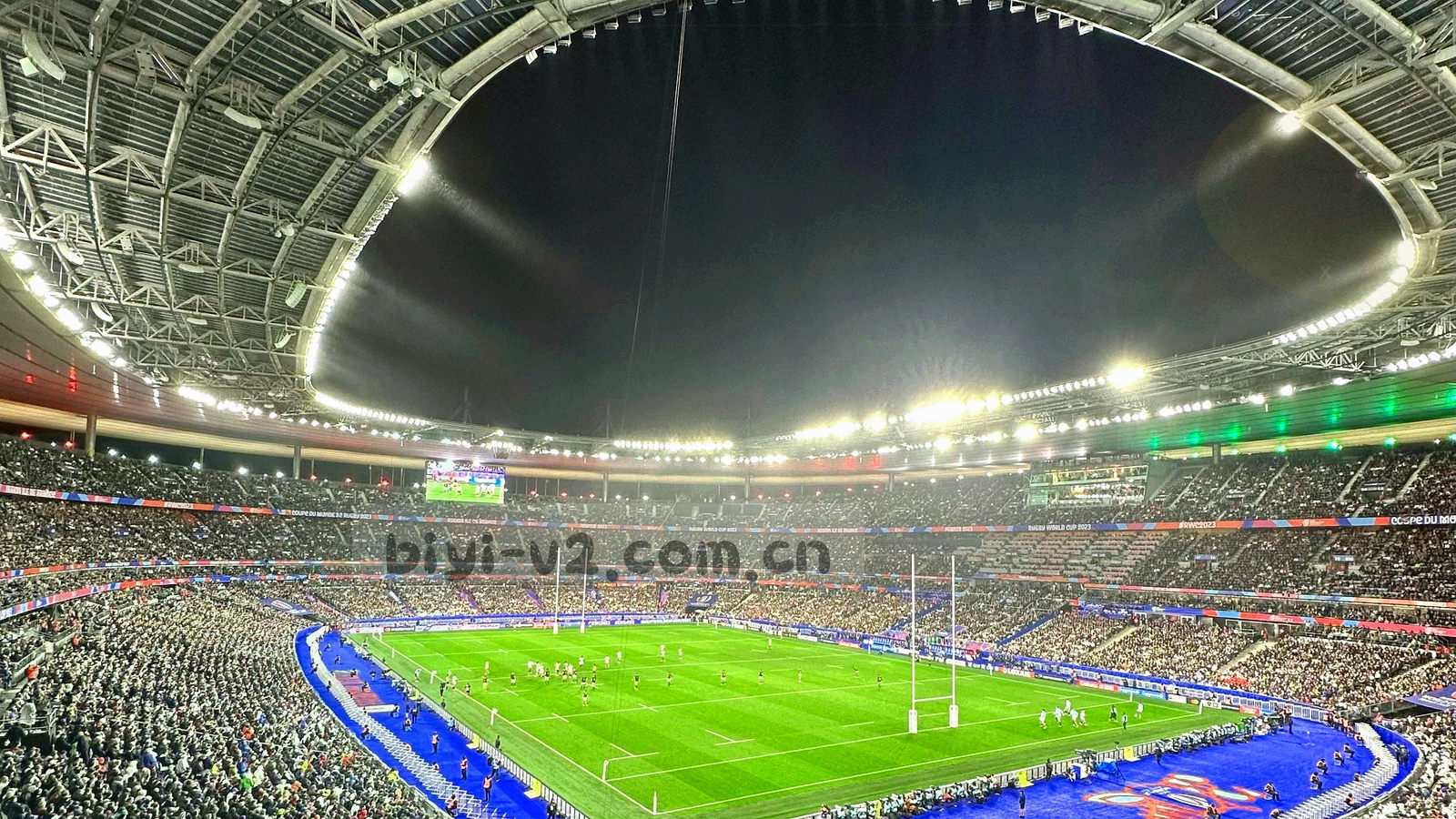 夜间场馆外部的低角度剪影，灯光与建筑线条被抽象成冷蓝色块